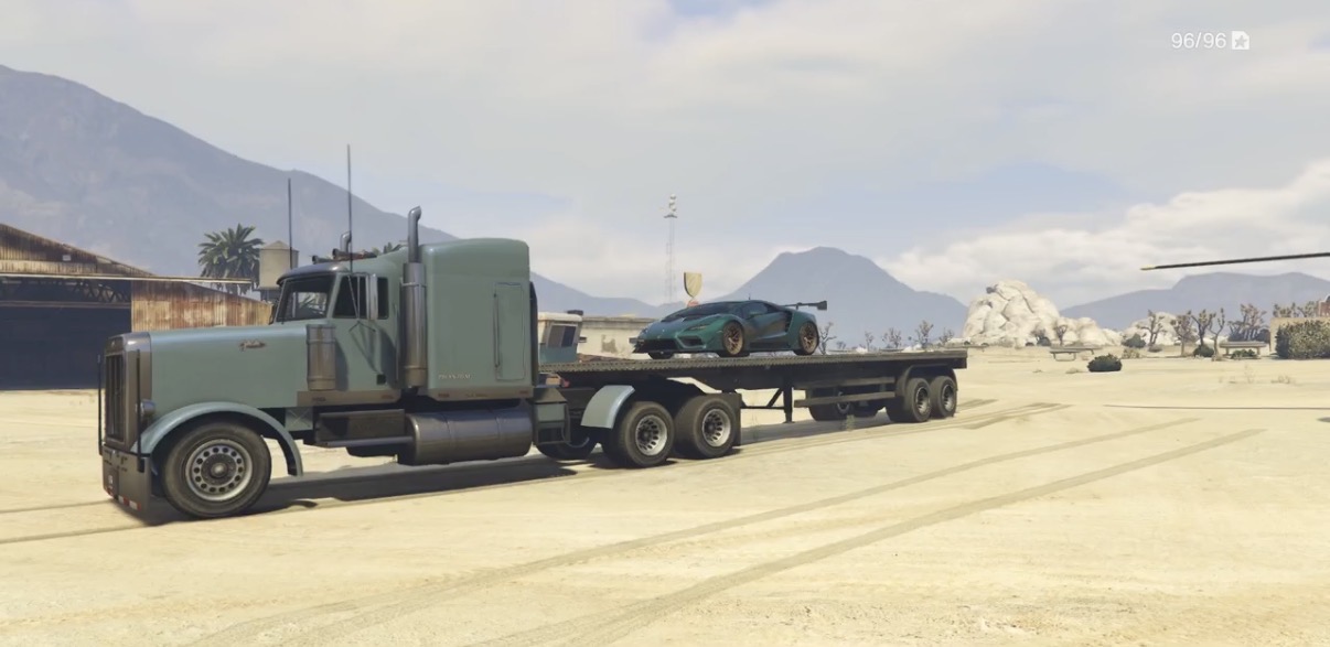Flatbed hauling a supercar through the desert